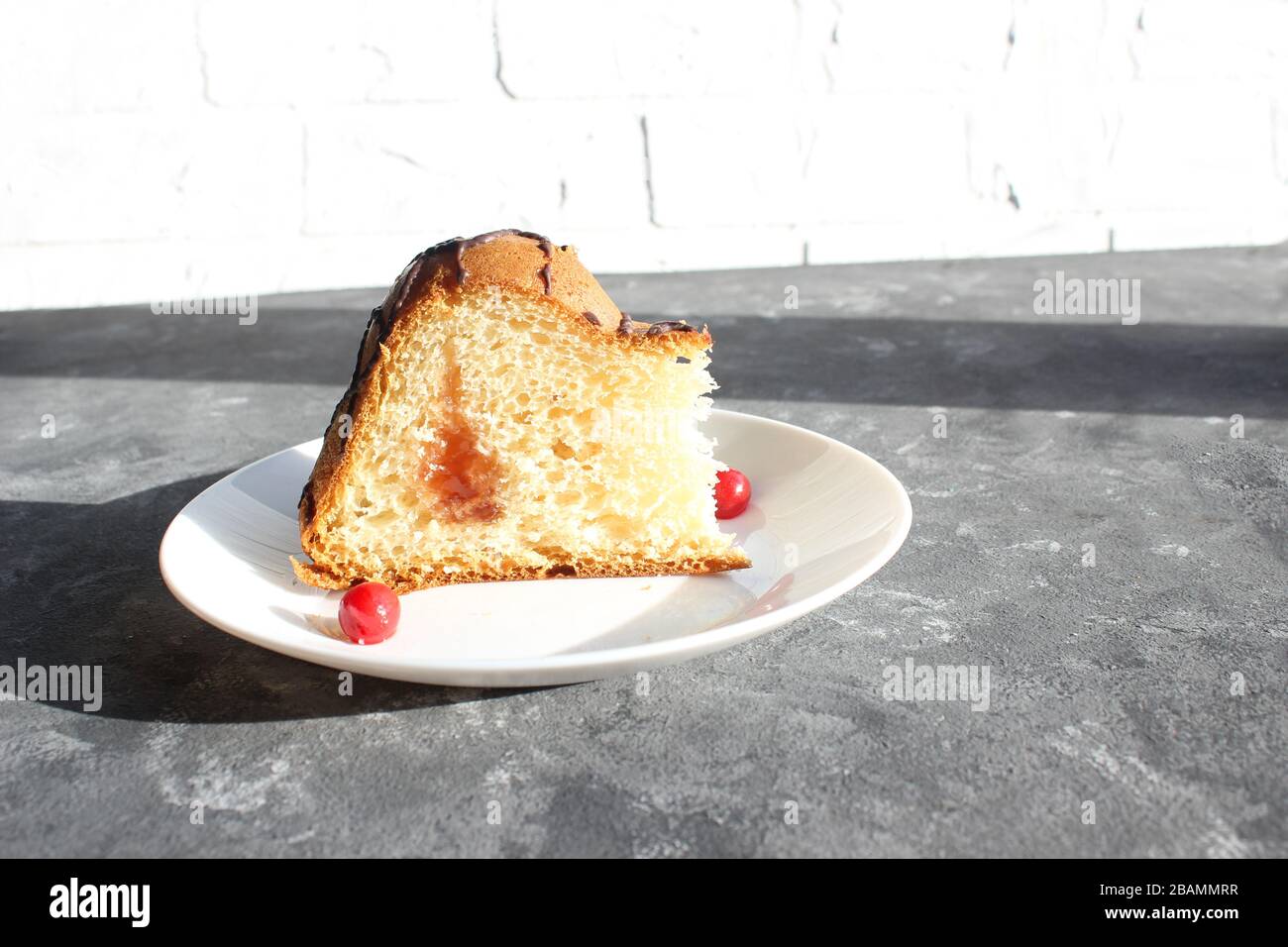 Délicieux gâteau sur la plaque sur la table. Tranches de gâteau sur une plaque. Baies d'une cerise sur un gâteau. Fraise et remplissage crémeux. Fond sombre Banque D'Images