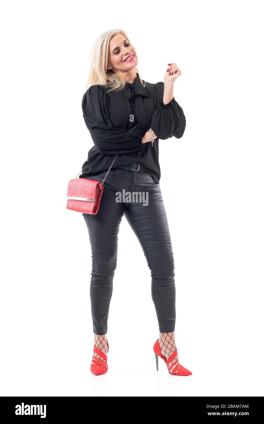 Satisfait heureux bonne santé 50 ans dame en soirée élégante porter sourire et regarder loin tenir bras. Longueur totale du corps isolée sur fond blanc. Banque D'Images