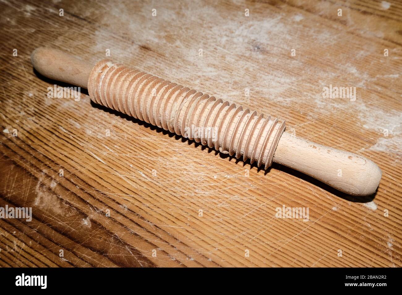 Broche de roulement isolée en bois strié sur table en bois, articles de cuisine faits maison Banque D'Images