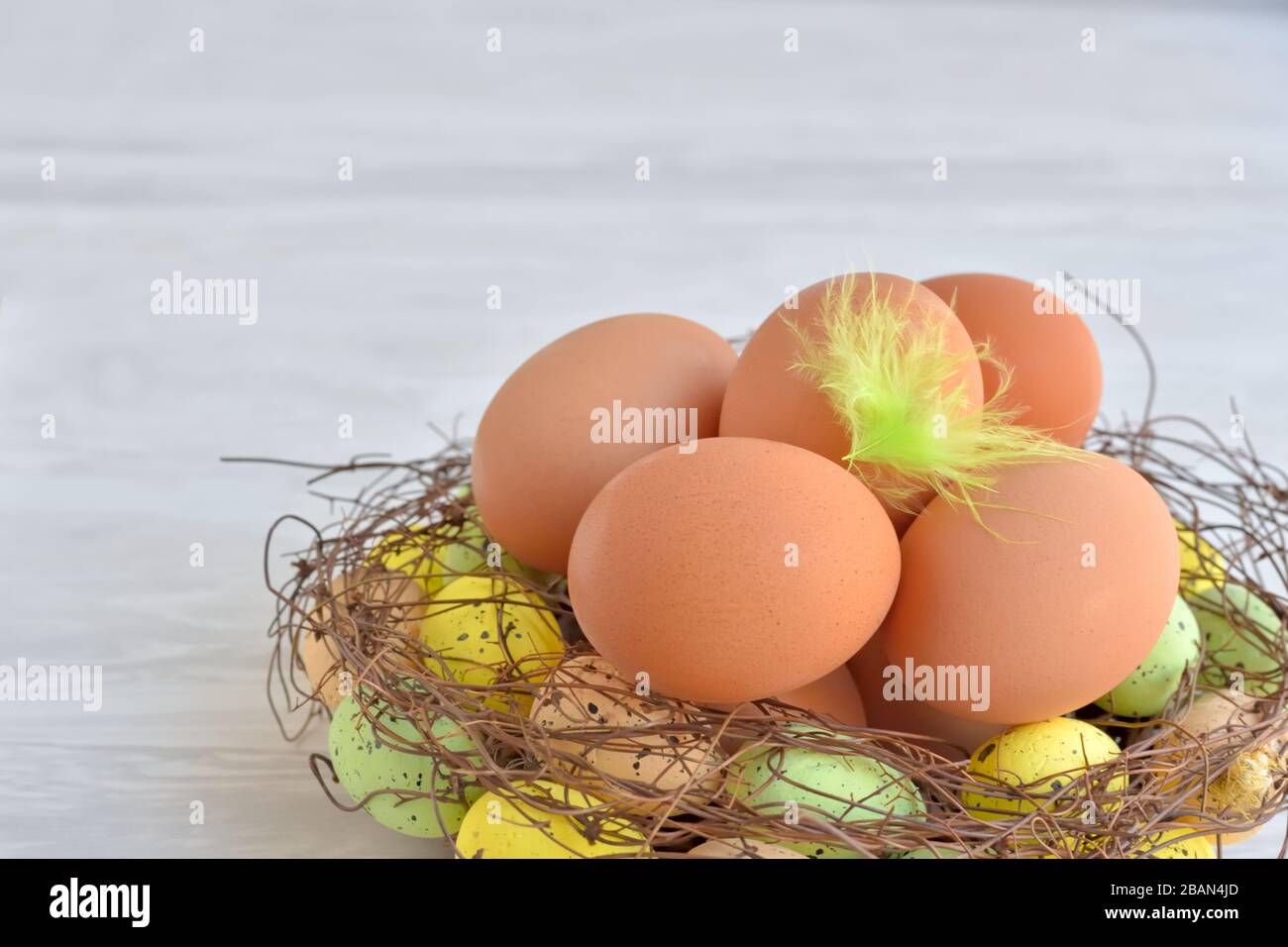 Œufs de Pâques empilés dans une couronne sous la forme d'un nid, décor maison festif fait main, espace copie Banque D'Images