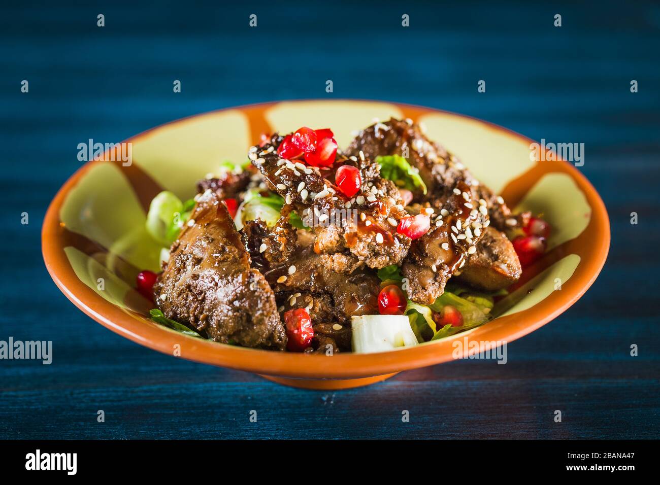 Poêle de plat traditionnel japonais yakitori - coeur frits de checken servi avec du sésame, de la sauce teriyaki et des légumes frais à bord de bois isolé à Banque D'Images