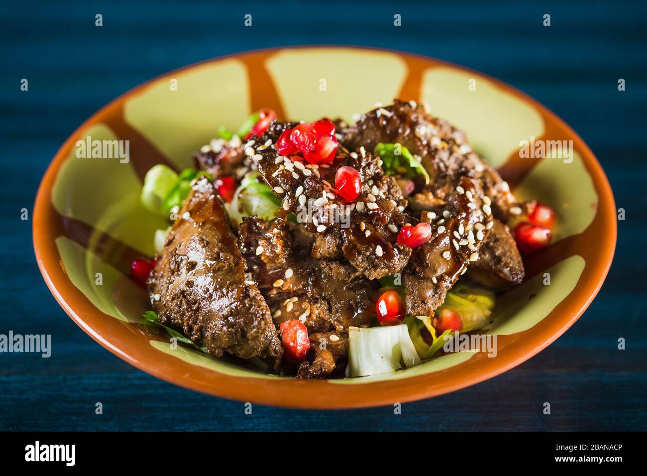 Poêle de plat traditionnel japonais yakitori - coeur frits de checken servi avec du sésame, de la sauce teriyaki et des légumes frais à bord de bois isolé à Banque D'Images