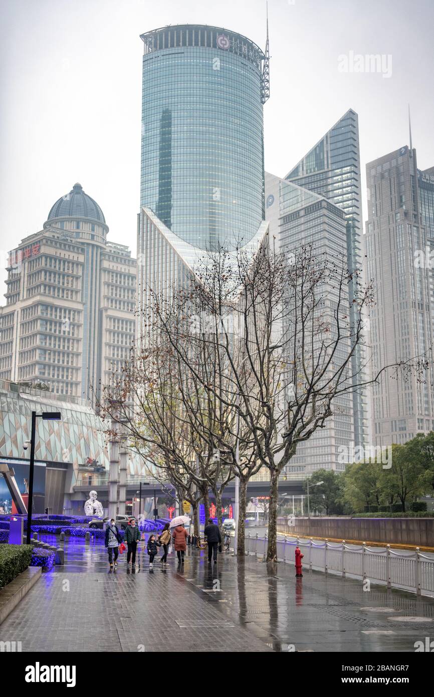 Des bâtiments imposants s'étendant dans les nuages qui se profilent au-dessus des gens qui descendent en contrebas, Shanghai, Chine Banque D'Images