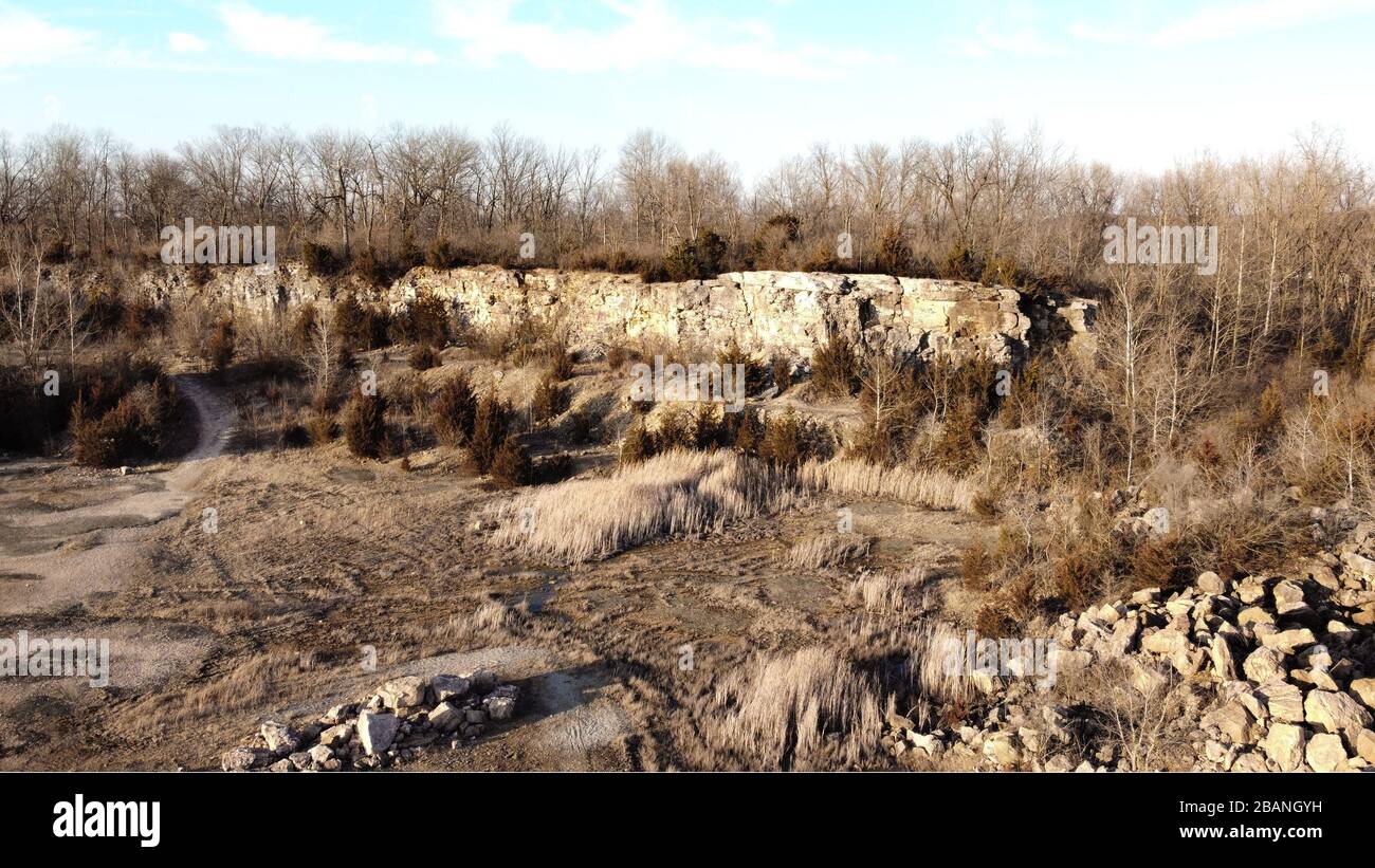 Carrière de rock abandonnée au coucher du soleil. Vue de haut au-dessus d'un plan stérile. Étangs et plantes mortes Banque D'Images