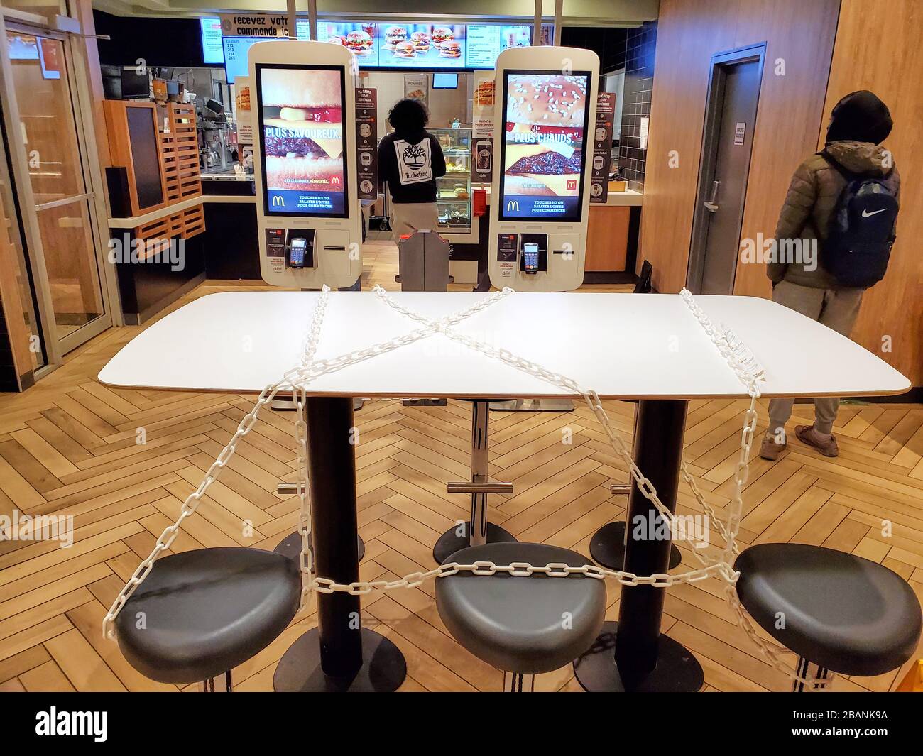 Montréal, Canada - 22 mars 2020: Sièges et tables à chaîne chez McDonald's en raison du coronavirus. De nombreux restaurants et Fast-food mettent de la chaîne sur les tables Banque D'Images