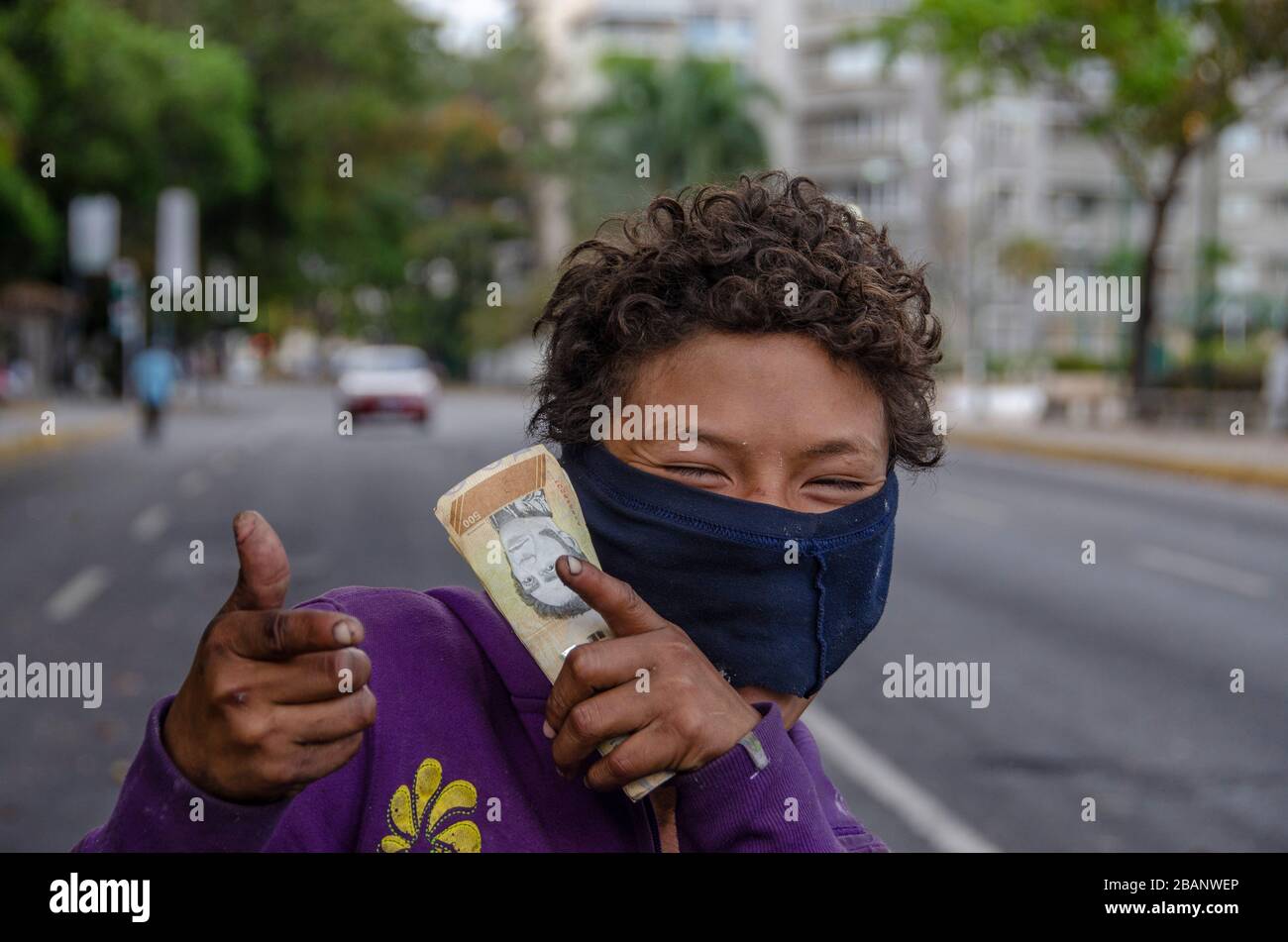 Un garçon sans abri couvre son visage avec une chemise déchirée pour se protéger du virus. Quarantaine en raison de l'apparition du virus Covid-19. A Banque D'Images