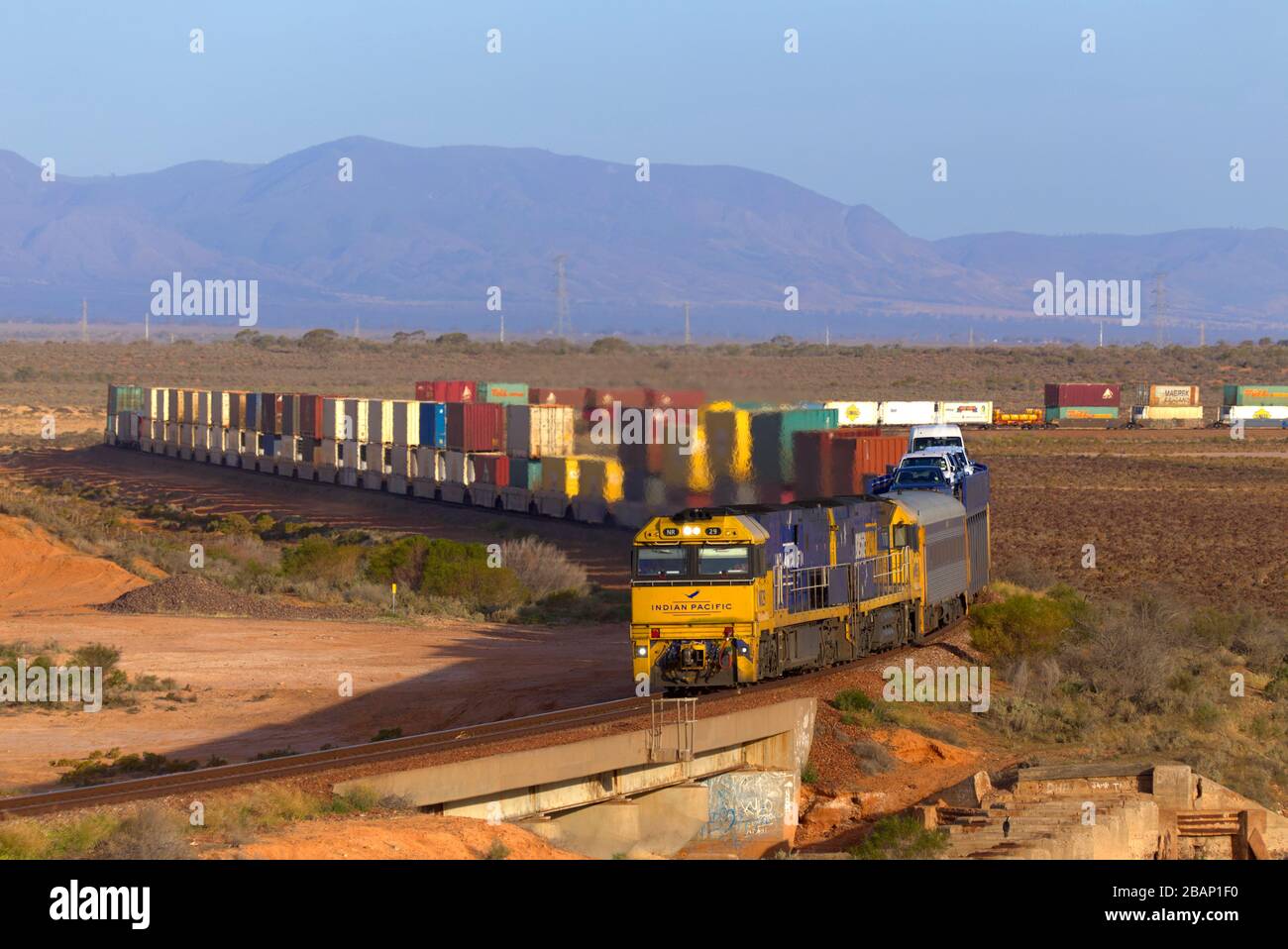 Train de fret transportant des modules empilés doubles - conteneurs d'expédition à travers le paysage plat près de Port Auguata Australie méridionale Banque D'Images