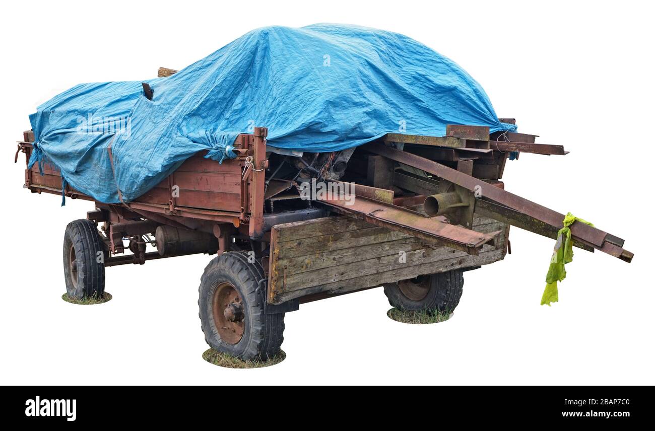Le vieux chariot de tracteur rural rouge wuith bois grumes et le couvercle  en plastique bleu de bâche isolé sur blanc Photo Stock - Alamy