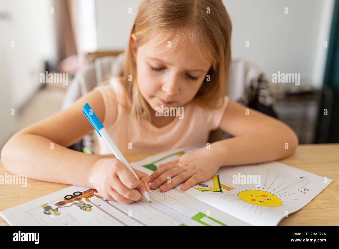 Jolie écolière étudiant les devoirs pendant sa leçon en ligne à la maison, distance sociale pendant la quarantaine covid-19, auto-isolement, éducation en ligne Banque D'Images