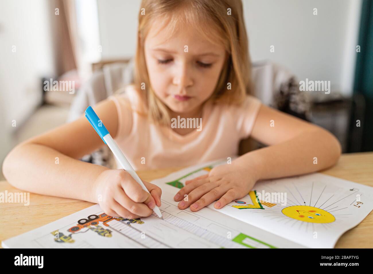 Jolie écolière étudiant les devoirs pendant sa leçon en ligne à la maison, distance sociale pendant la quarantaine covid-19, auto-isolement, éducation en ligne Banque D'Images