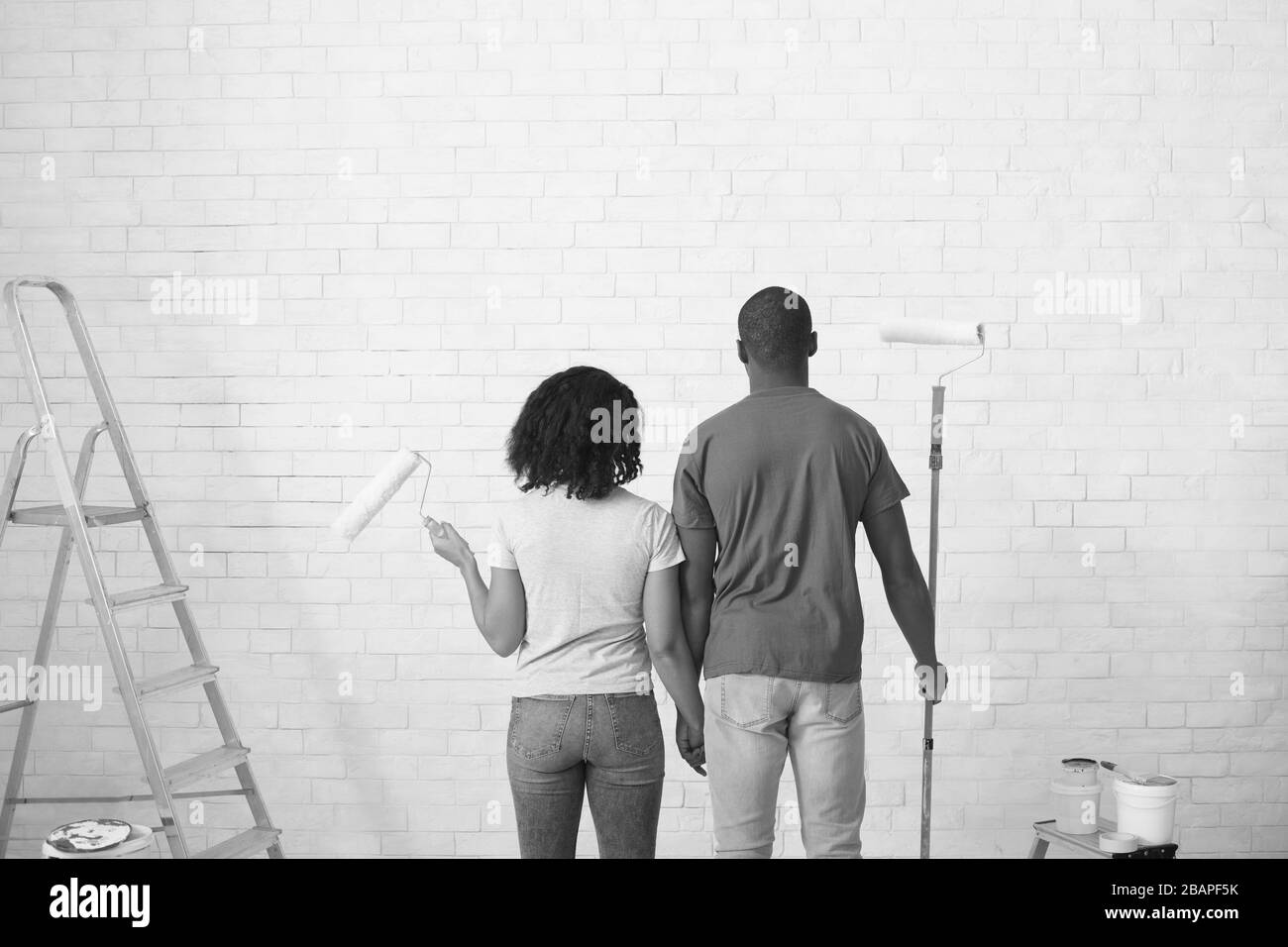 Couple afro-américain avec rouleaux en mains noir et blanc photo Banque D'Images