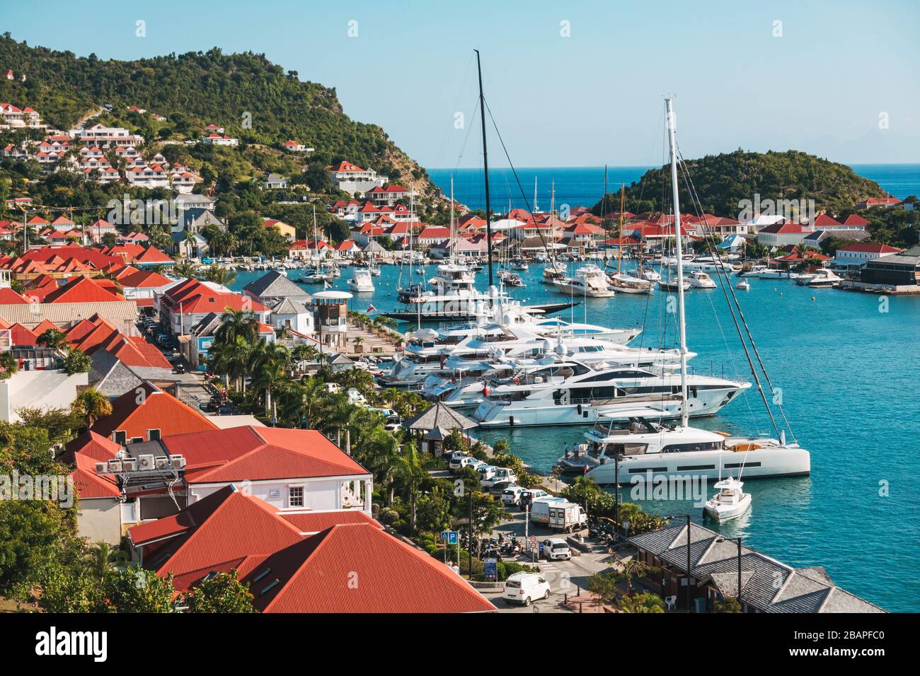 Yachts privés garés par les toits rouges distincts des maisons et des magasins dans la ville portuaire bien entretenue de Gustavia, capitale de Saint Barthélemy Banque D'Images