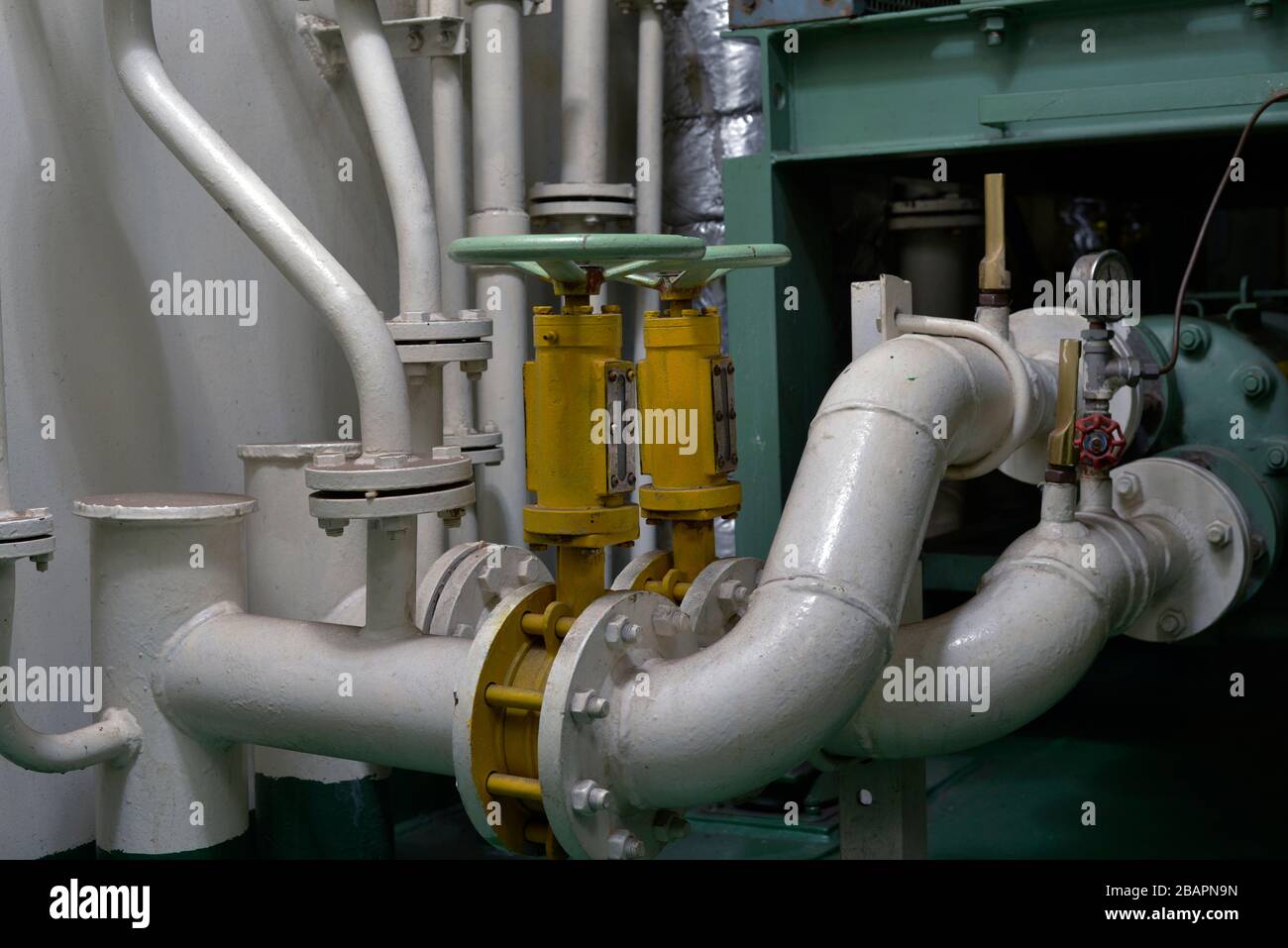 Intérieur de la salle des machines d'un grand océan allant navire avec des tuyaux blancs et des vannes Banque D'Images