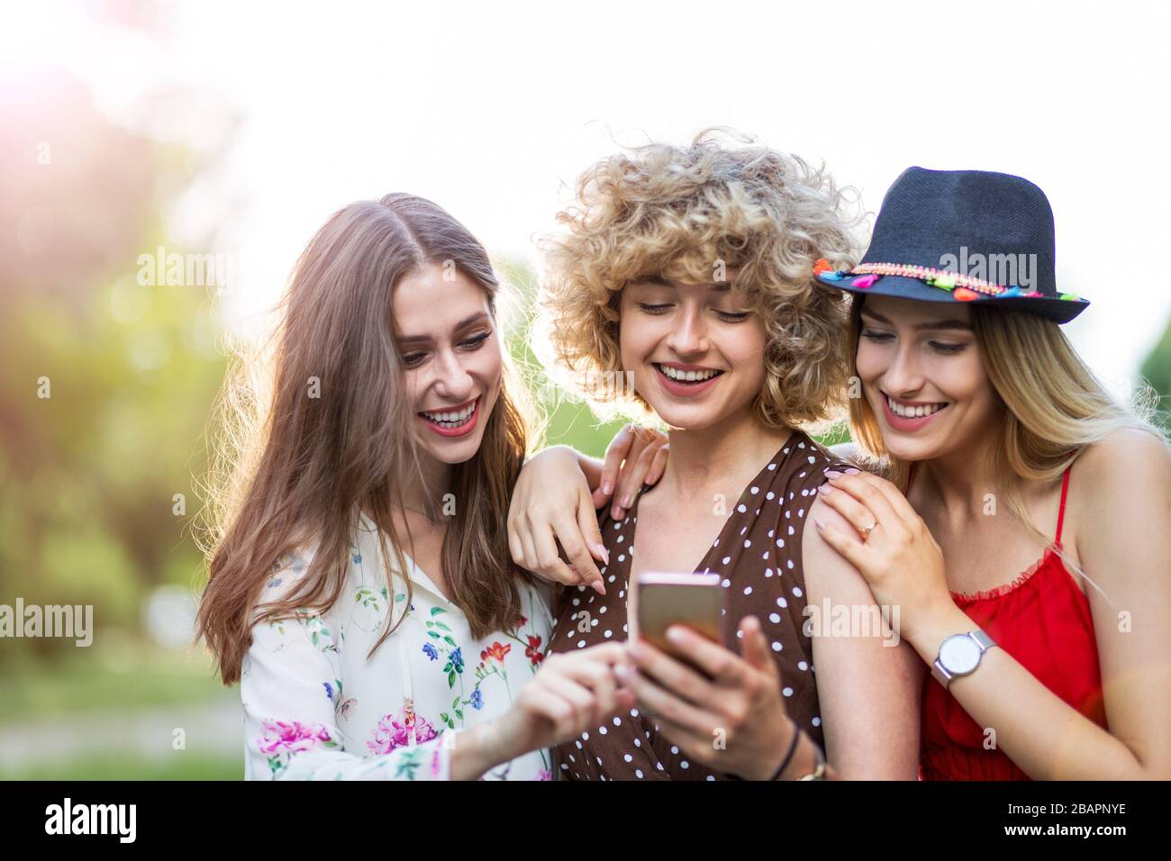 Trois jeunes femmes heureuses qui s'amusent avec un smartphone Banque D'Images