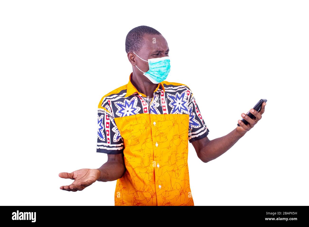 surpris jeune homme portant un masque médical sur son visage regardant le téléphone portable. Banque D'Images