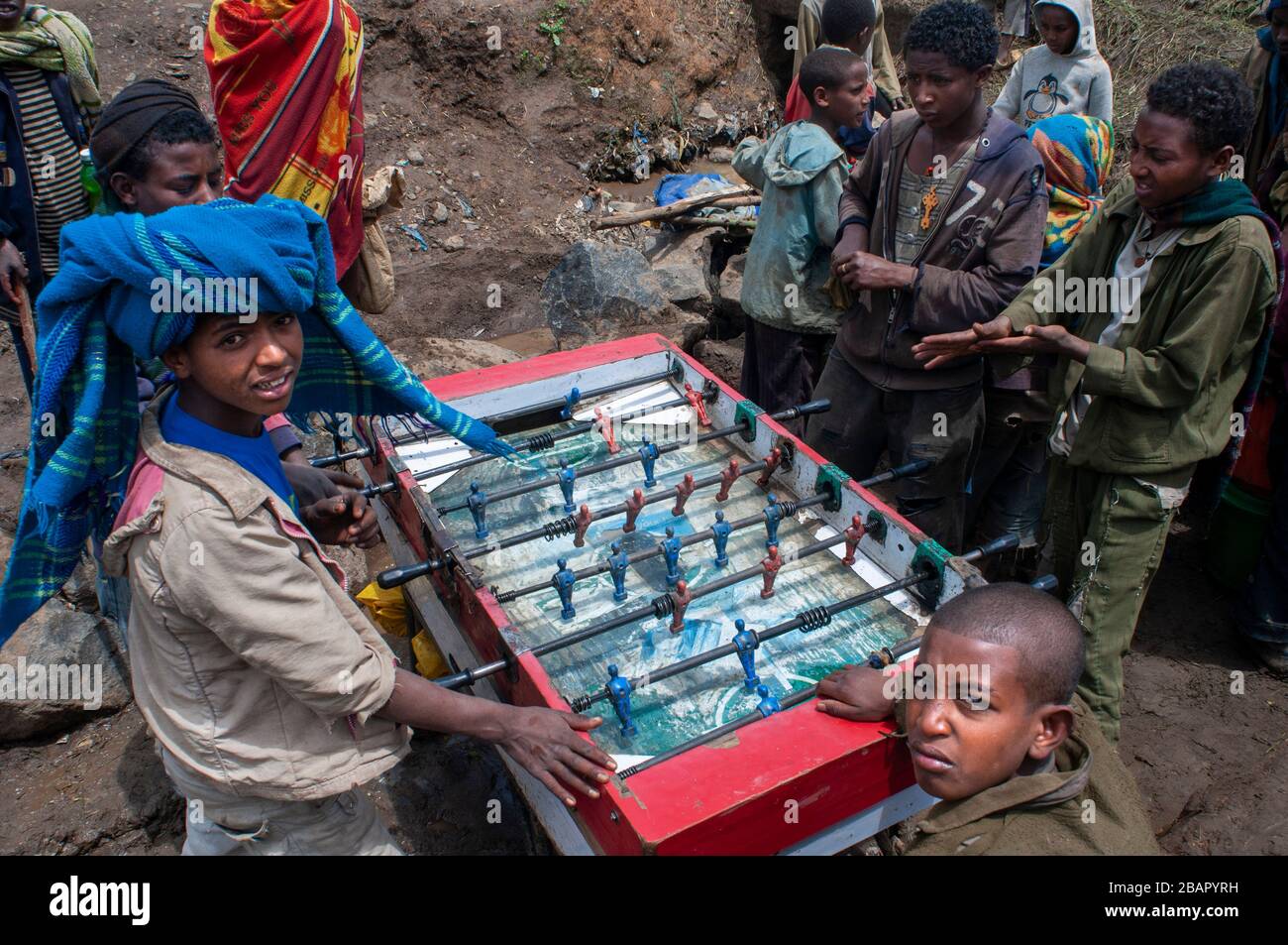 Place du marché. Déchargent. Les montagnes du Simien. Le nord de l'Éthiopie. Marché écorcer. Plusieurs enfants jouer au baby-foot pendant que leurs parents vendent ou achètent. E Banque D'Images