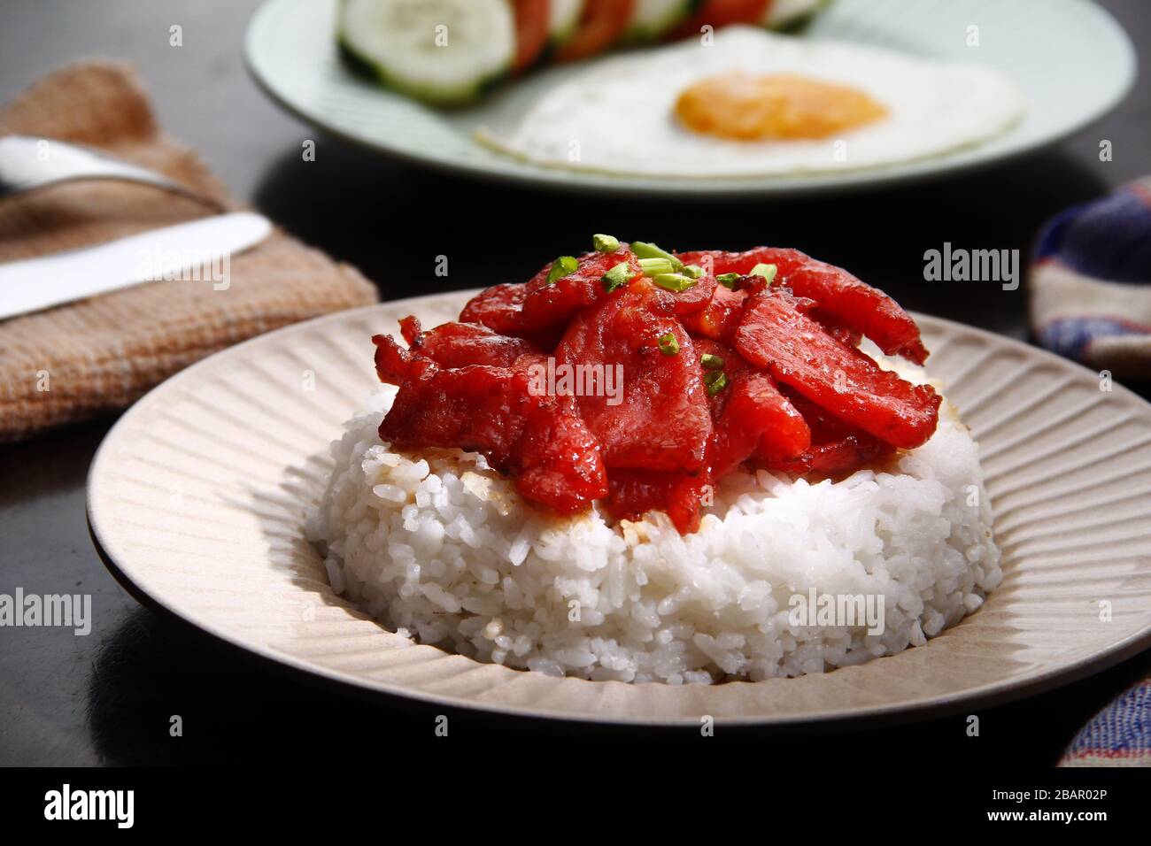 Photo de Tocino fraîchement cuit ou de viande de porc cuite servie avec du riz frit et des œufs avec des légumes. Banque D'Images