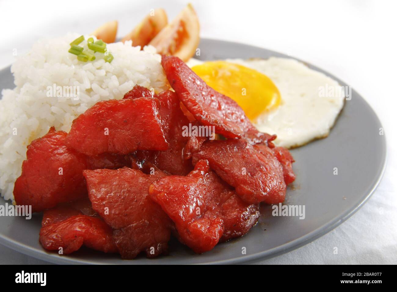 Photo de Tocino fraîchement cuit ou de viande de porc cuite servie avec du riz frit et des œufs avec des légumes. Banque D'Images