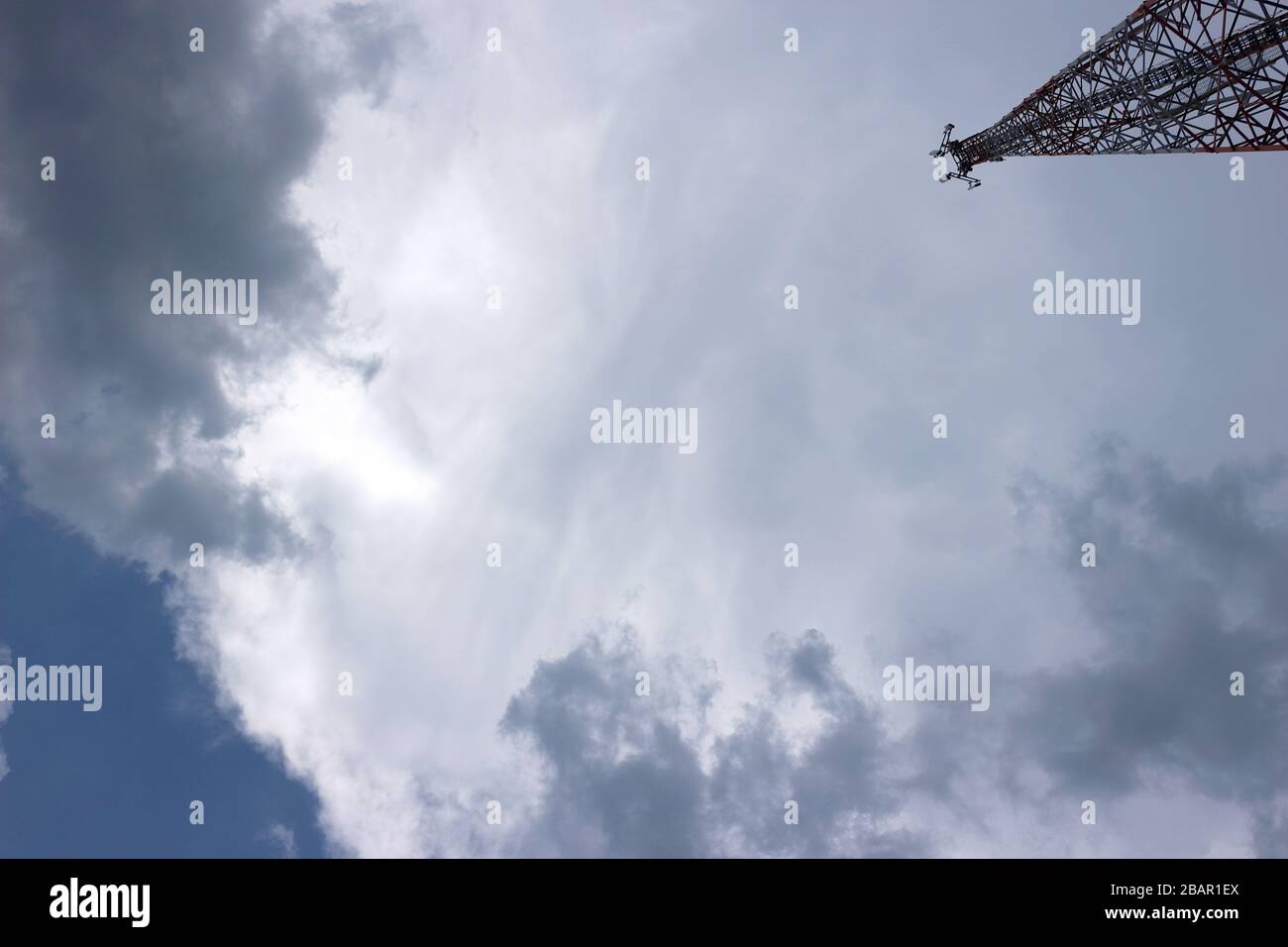 Cette photographie au niveau du sol représente la structure en acier complexe d'une tour de télécommunication, mettant en valeur sa construction robuste. Banque D'Images