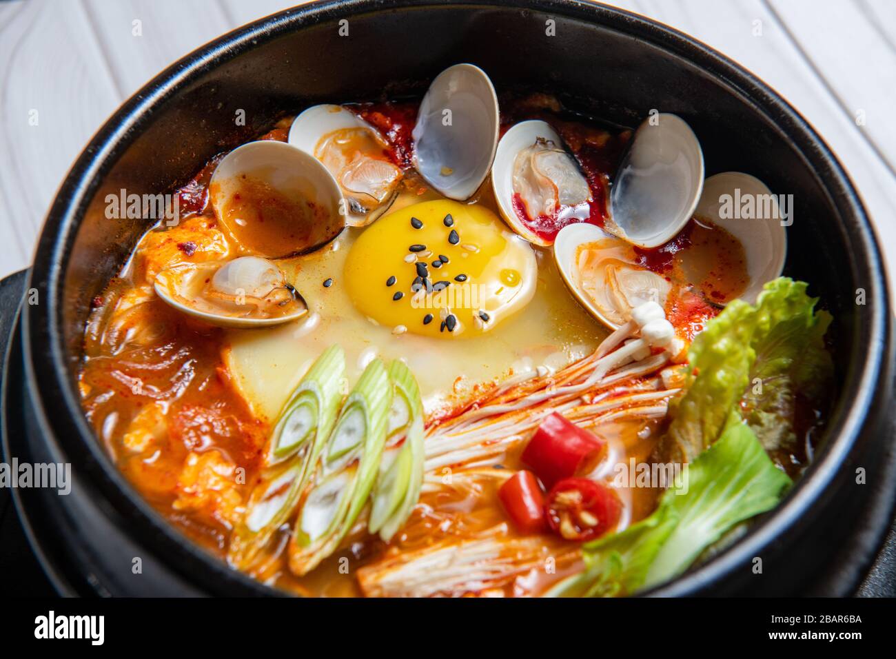 Le ragoût de kimchi jjigae ou de kimchi est un plat coréen composé de kimchi et d'autres ingrédients, tels que des échalotes, des oignons, du tofu coupé en dés, du porc, du thon et des fruits de mer. Banque D'Images