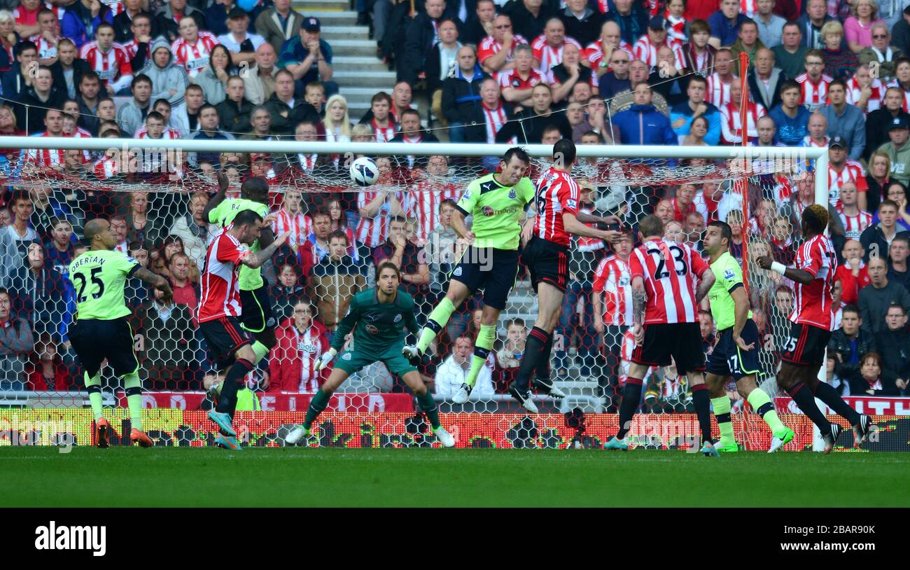 John O'Shea (au centre) de Sunderland dirige la balle vers le but où il frappe Demba Ba (obscurci) de Newcastle United avant d'aller dans le filet pour l'objectif d'ouverture de son équipe Banque D'Images