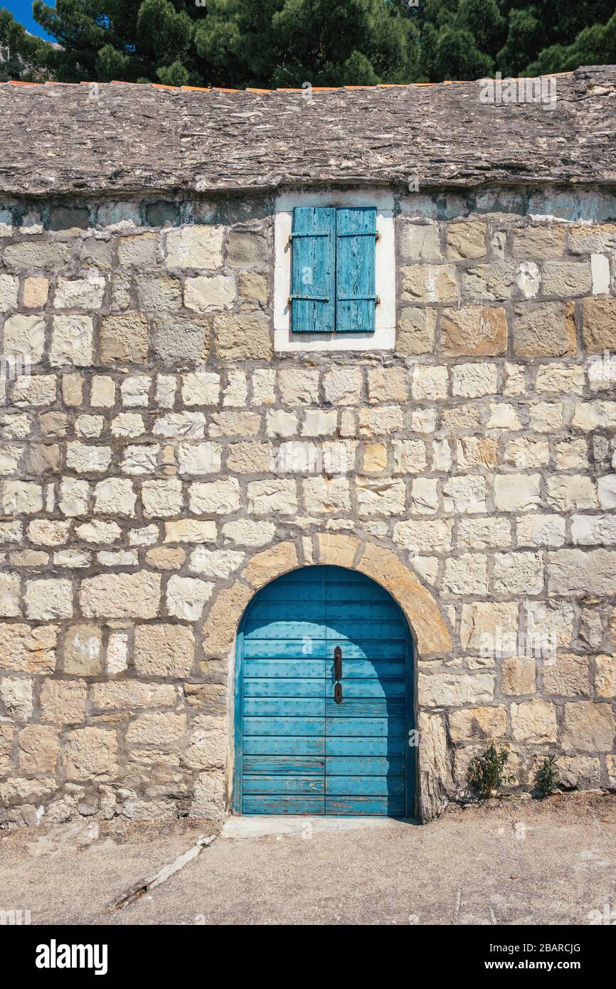 Maison traditionnelle en pierre avec porte bleue et fenêtre en Croatie Banque D'Images