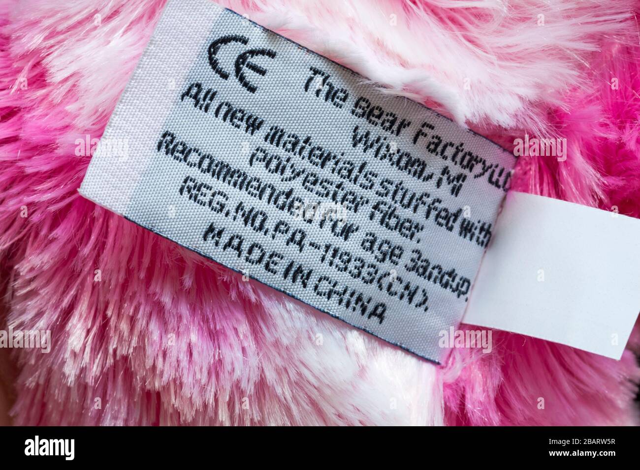 Dans l'étiquette de l'ours blanc et rose par l'ours fait en usine en Chine, tous les nouveaux matériaux farci de fibres en polyester, recommandé pour l'âge 3andup, symbole CE Banque D'Images