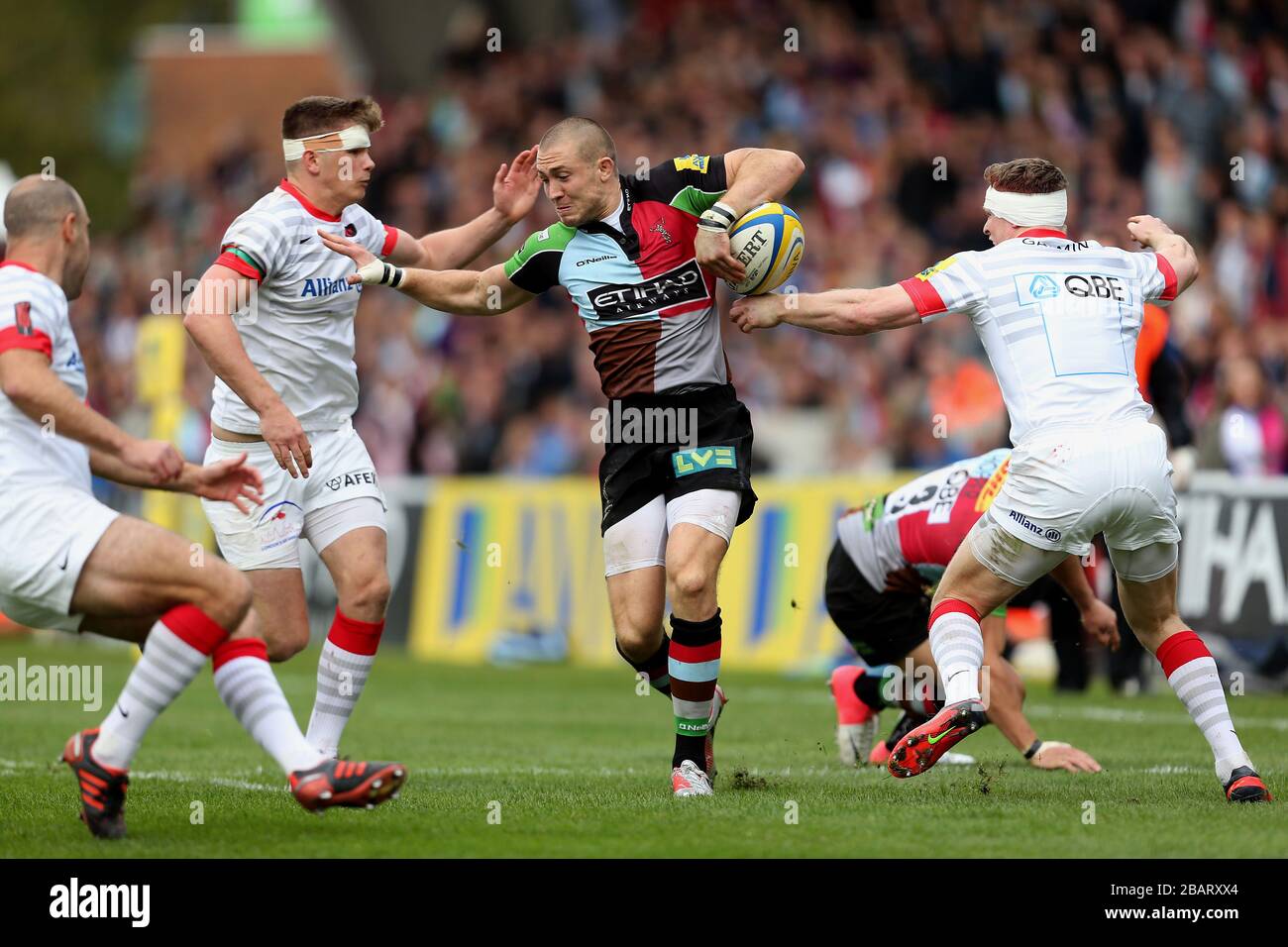 Mike Brown de Harlequins perd le ballon sous la pression de Saracens Banque D'Images