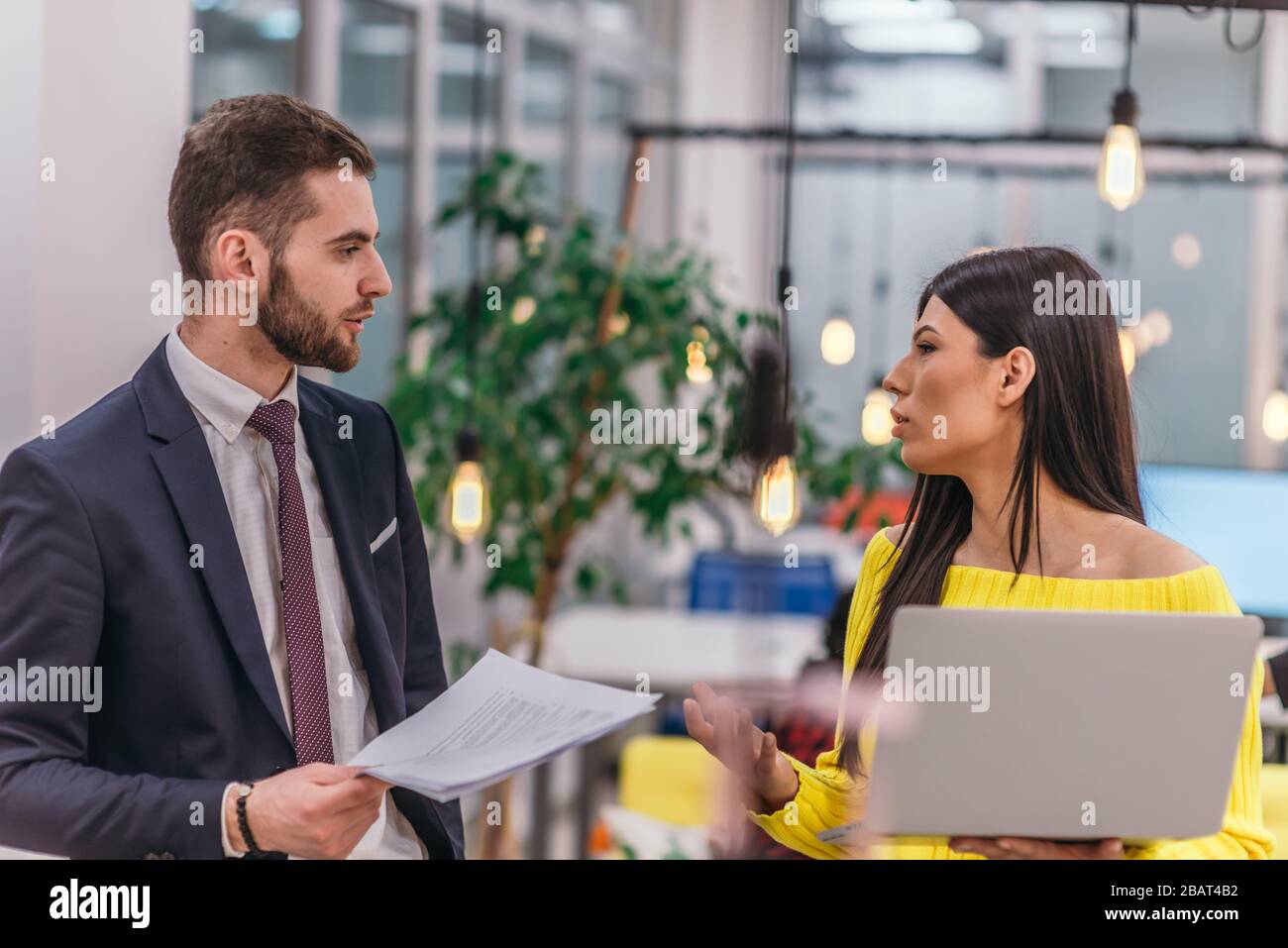 Le responsable explique à son employé comment terminer ses tâches. Collègues discutant d'un projet en se tenant dans un bureau. Banque D'Images