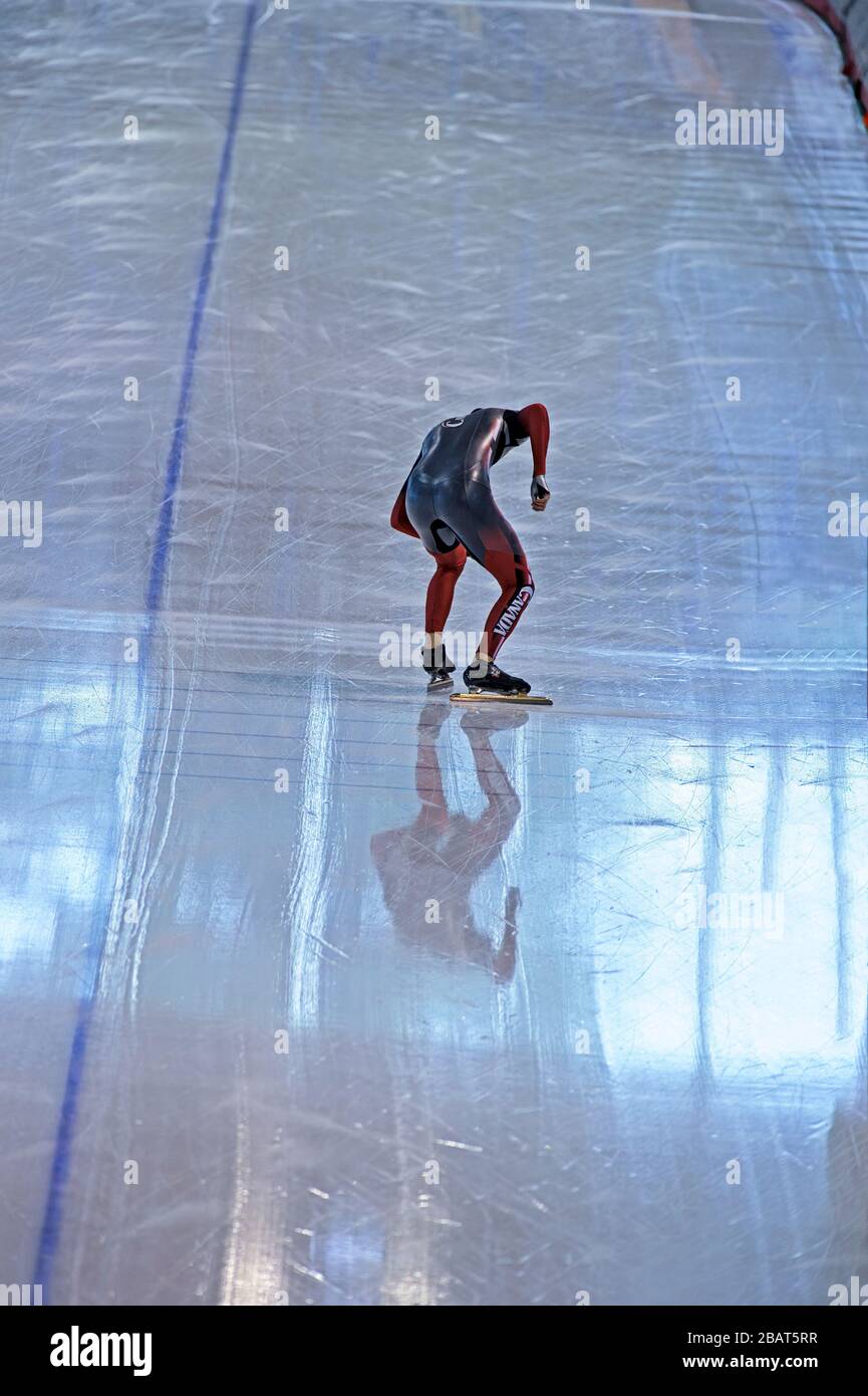 La patineuse de vitesse dans la formation sportive, pratiquant à la ligne de départ d'un anneau de patinage de vitesse Banque D'Images