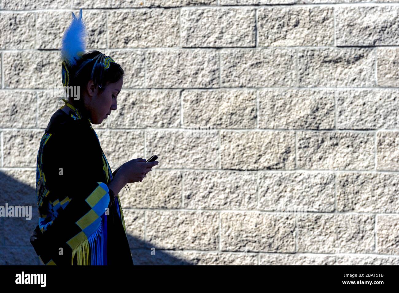 Jeune fille des Premières nations utilisant un smartphone alors qu'elle était à un powwow à calgary, Alberta Canada Banque D'Images