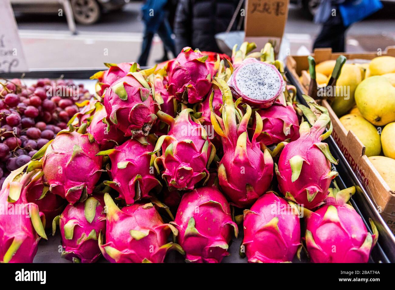 Le fruit du Dragon rouge, également connu sous le nom de Pitahaya, ou Pitaya, s'est enroulé en hauteur avec une tranche de moitié en exposition pour la vente dans un quartier chinois, stand de fruits, New York City Banque D'Images