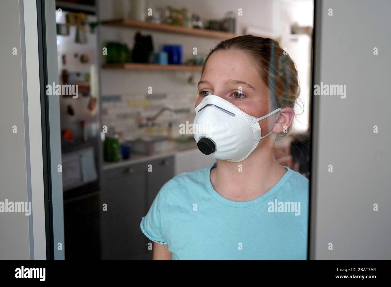 Jeune fille portant un masque de visage à la maison - confinement Banque D'Images