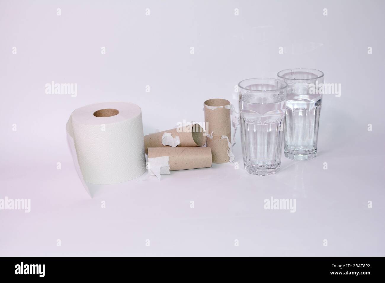 Buvez beaucoup en cas de diarrhée - rouleaux de papier toilette pleins et vides avec deux verres d'eau avec espace de copie Banque D'Images