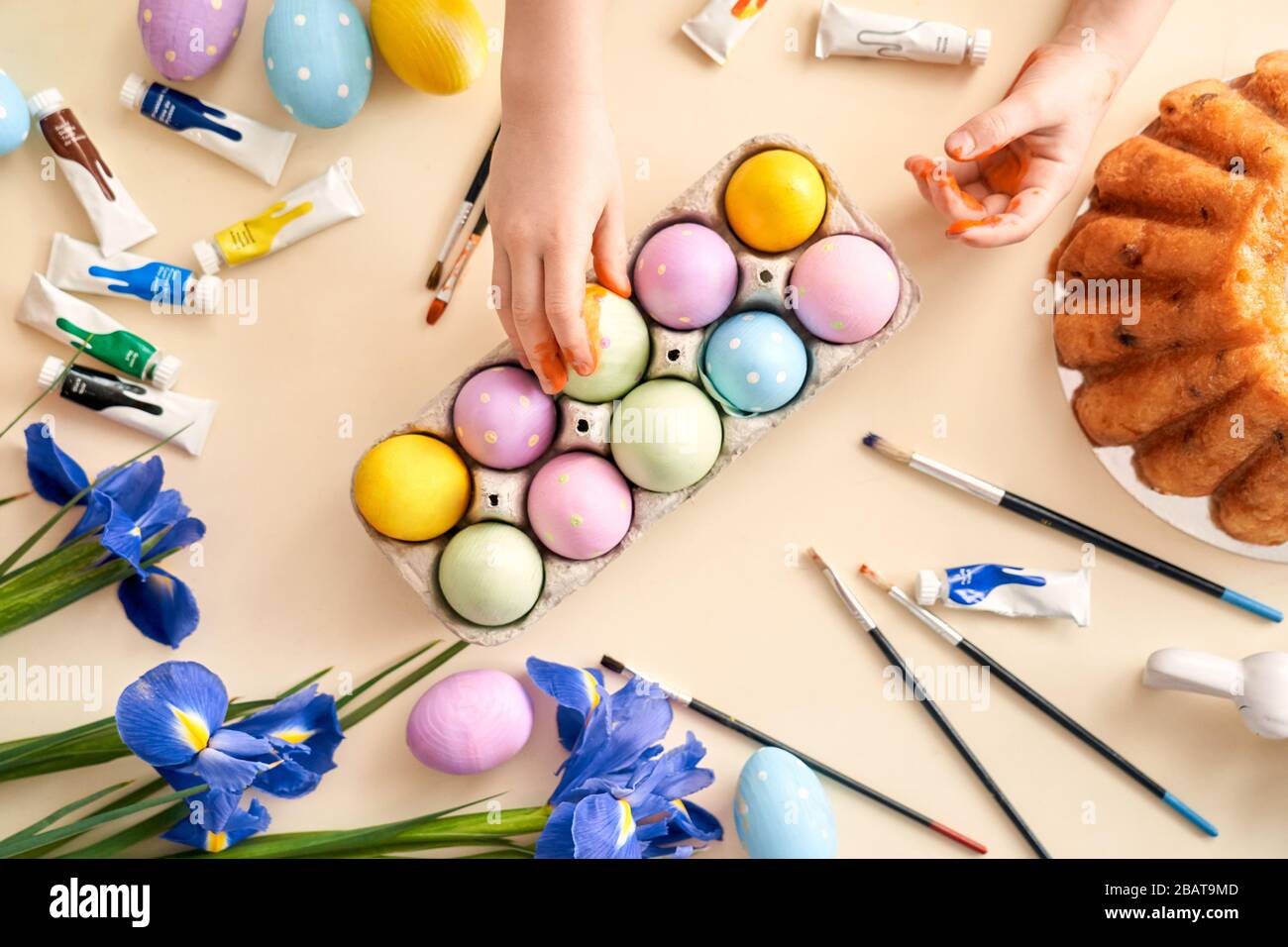 Petite fille de Pâques touchant des objets de Pâques sur la table Banque D'Images