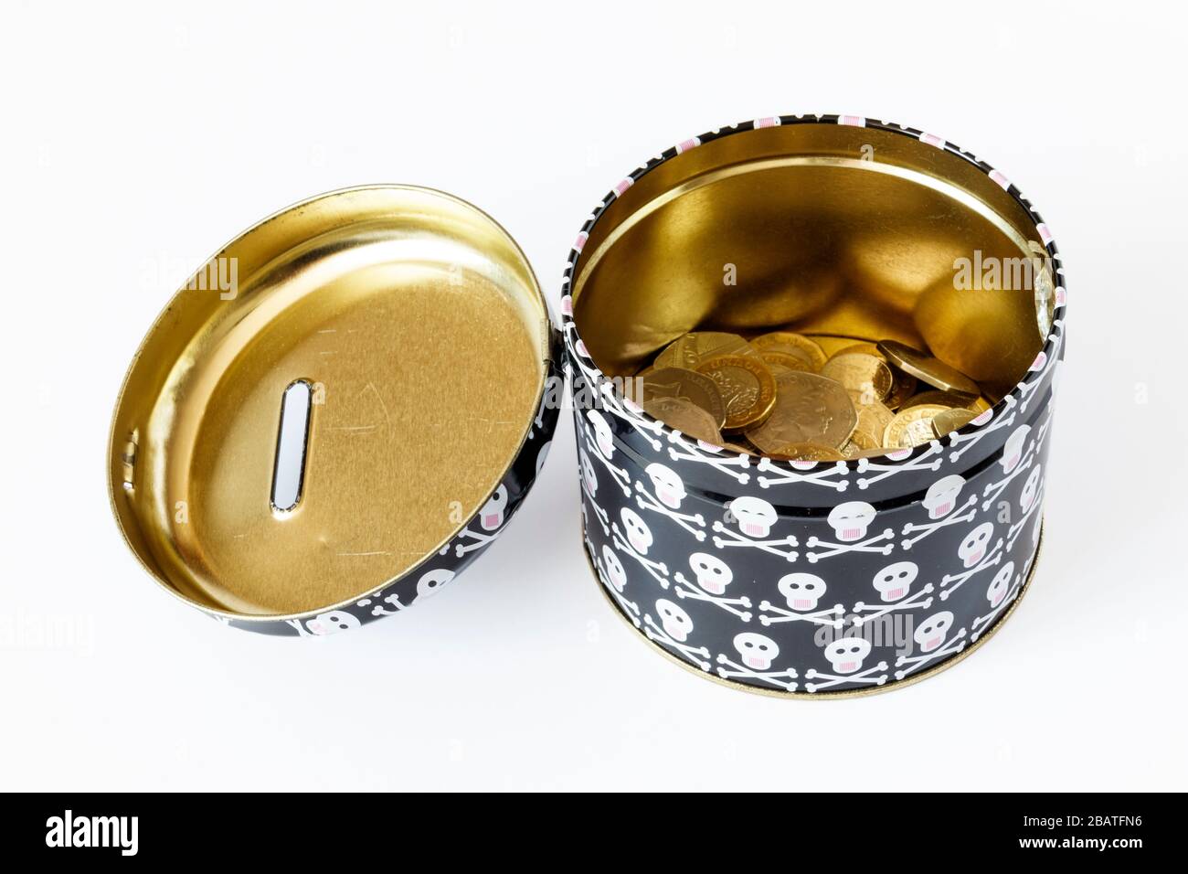 Une caisse en métal ouverte avec motif têtes de mort et croisillons et une étiquette manuscrite « fonds de jour de mort », contenant 1 £ et 2 pièces Banque D'Images