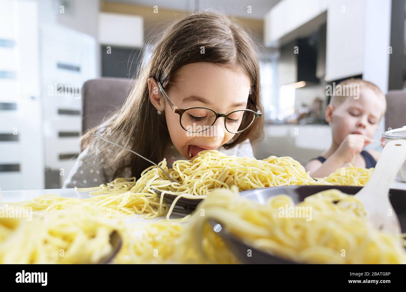 Portrait d'une petite fille mignonne mangeant des pâtes spaghetti Banque D'Images