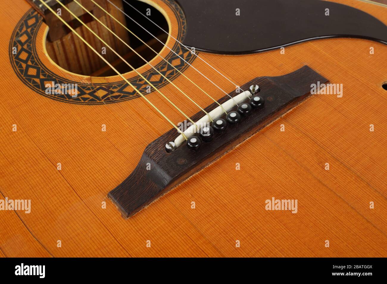 Instrument de musique - Fragment vue de dessus pickguard, pont, épingles et cordes vintage rétro guitare acoustique. Banque D'Images