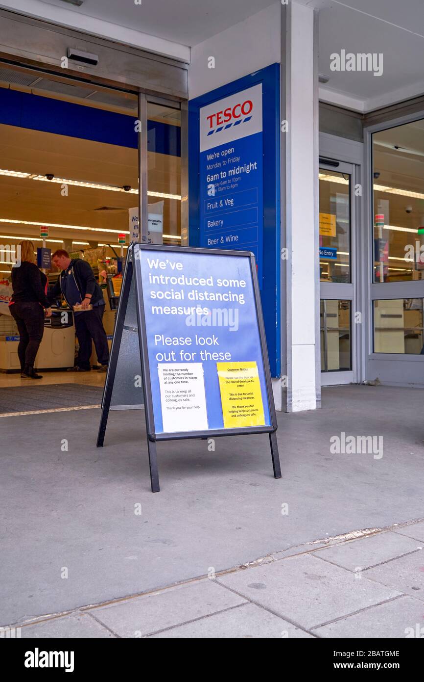 Panneau d'information sur les mesures de distanciation sociale à l'extérieur de l'entrée d'un supermarché Tesco pendant l'urgence du Coronavirus de Covid-19 Banque D'Images