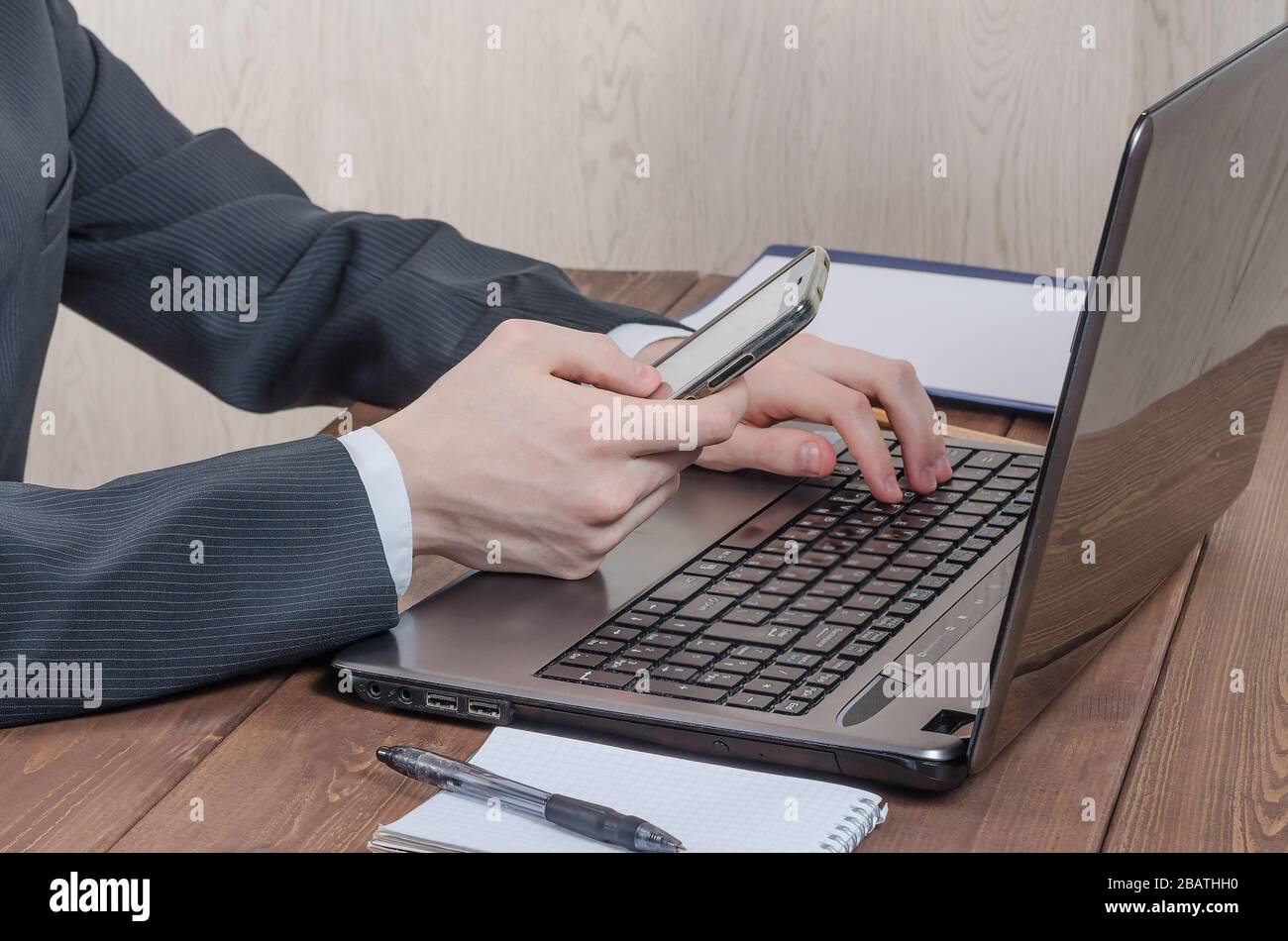 Jeune homme tenant un téléphone à la maison assis à un ordinateur portable shopping en ligne. Travail et éducation à la maison. Réseaux sociaux au travail. Problèmes de gel sur t Banque D'Images