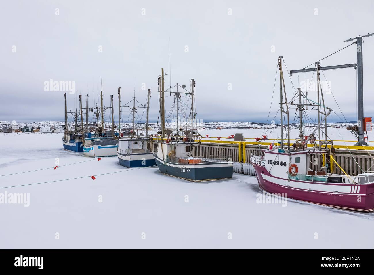 Bateaux de pêche ancrés dans le port de Fogo, pris dans la glace à Terre-Neuve, Canada Banque D'Images