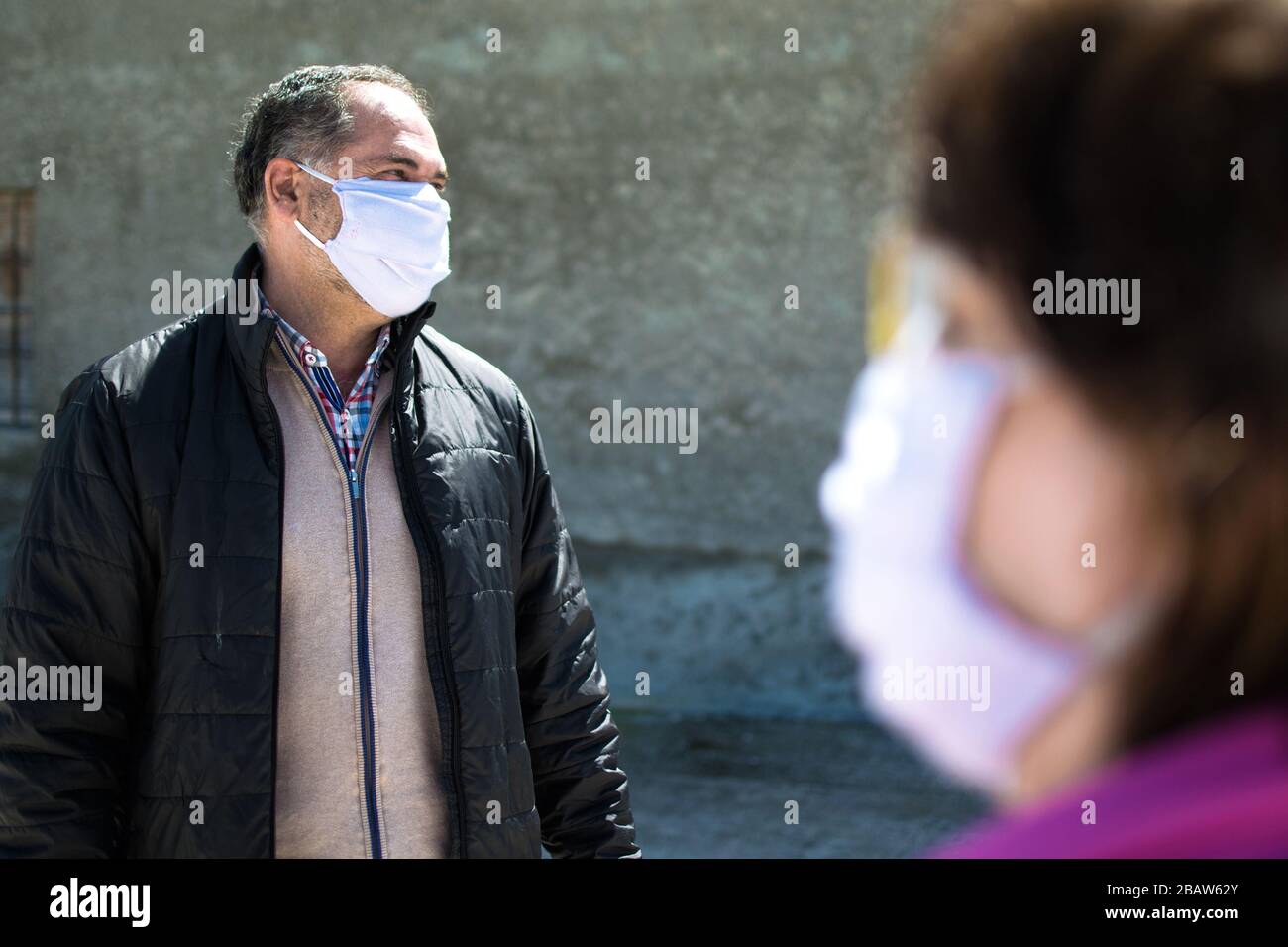 Deux personnes parlent de garder la distance de sécurité, porter un masque de protection pour le virus du coronavirus ou le virus du covid-19 dans une ville. Virus Corona, Covid-19. Banque D'Images