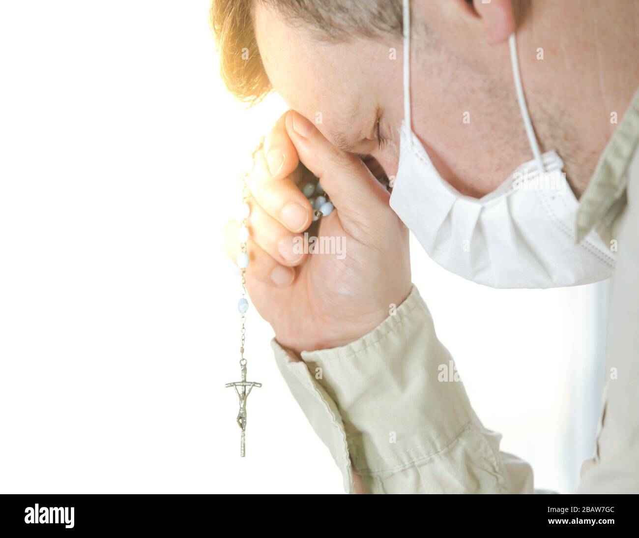 Éclosion de coronavirus : un homme portant un masque médical priant au-dessus de la pandémie mondiale de coronavirus pour réduire l'anxiété et la dépression. Homme tenant le rosaire Banque D'Images