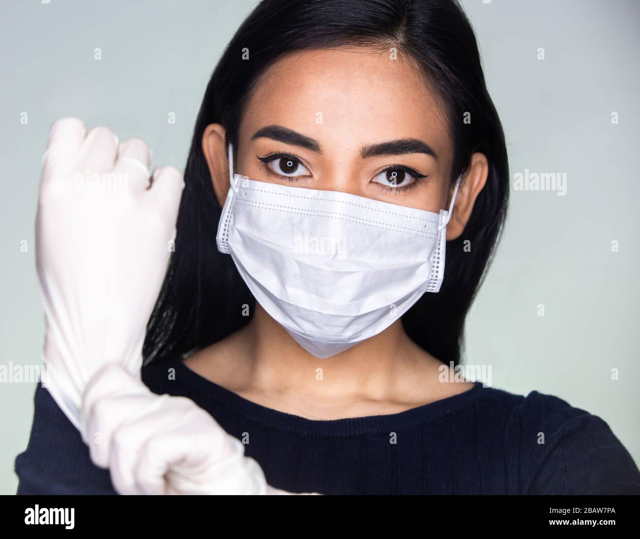 Jeune femme mettant des gants de protection contre le concept de virus  Corona. La jeune fille adulte en profil latéral porte un masque médical,  des gants, contre coron Photo Stock - Alamy