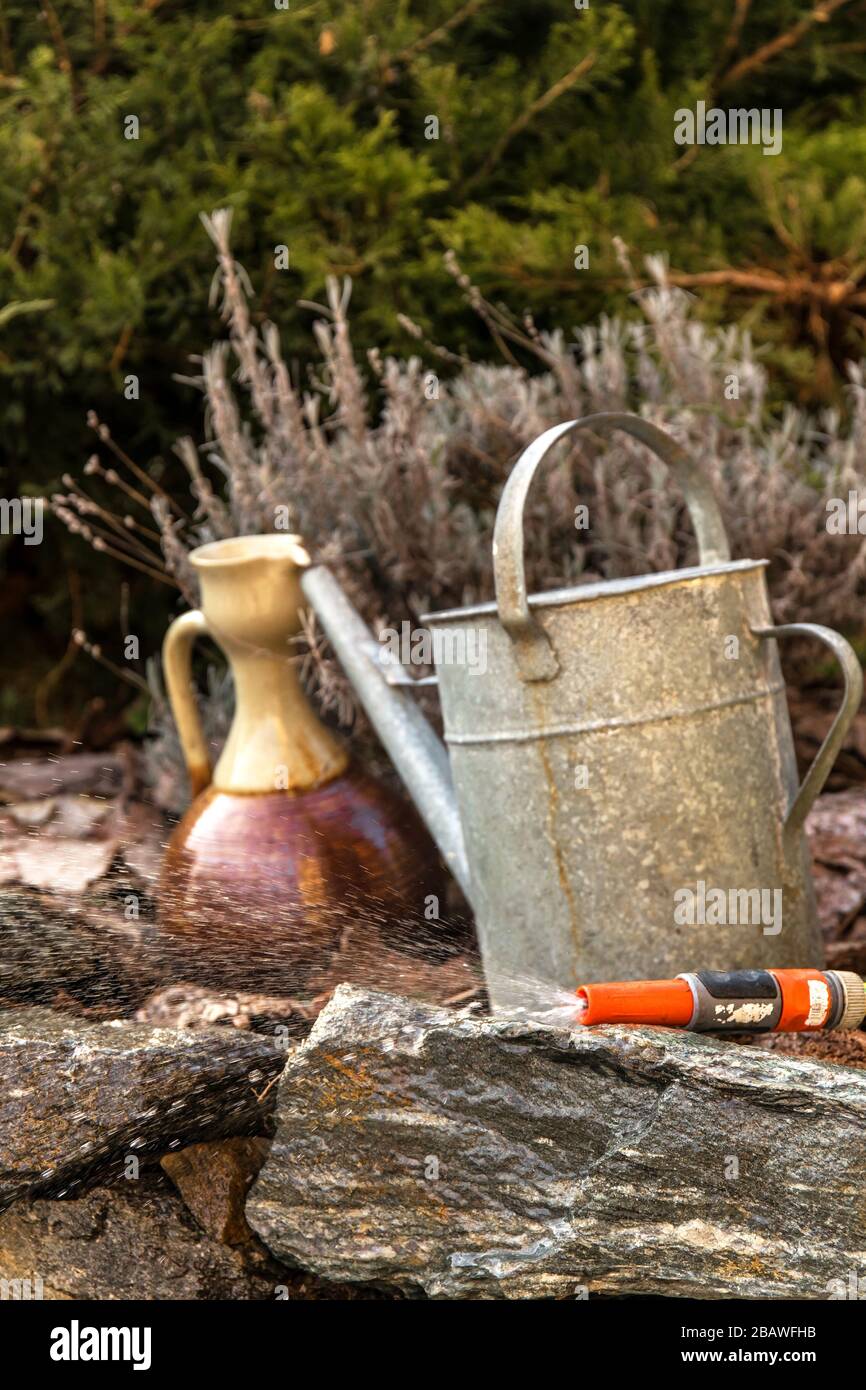 Arrosoirs. Arrosage du jardin. Outils du jardinier. Arrosoirs métalliques  anciens se tenant sur une roche dans un jardin Photo Stock - Alamy