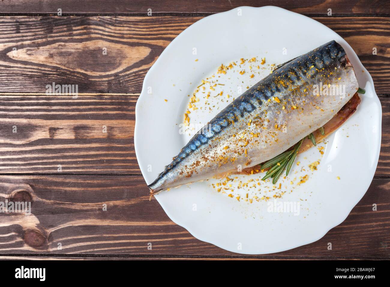 Maquereau mariné dans une plaque blanche. Poisson cru non préparé. Spécialités de fruits de mer traditionnelles, concept de saine alimentation. Sur le fond d'un plan d'examen en bois Banque D'Images