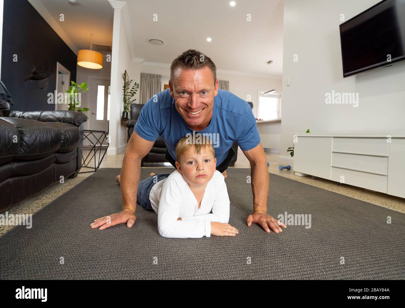 Arrêt COVID-19. Père et fils s'amuser à faire de l'exercice ensemble et rester physiquement actifs à la maison pendant la quarantaine du coronavirus. Restez à la maison, Exerc Banque D'Images