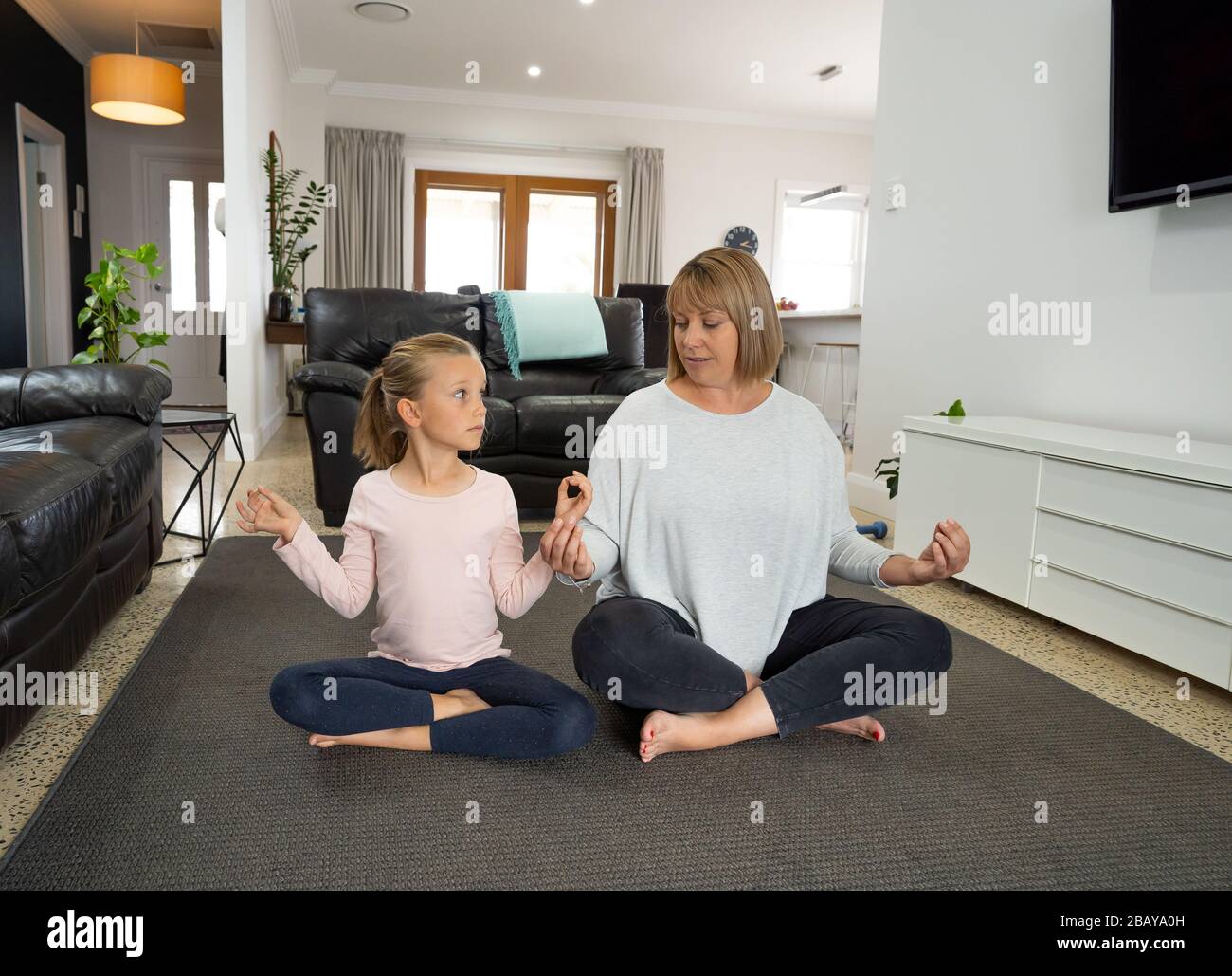 Arrêt COVID-19. La mère et la fille en quarantaine font du yoga à l'intérieur. Mère et fille faisant la méditation pendant le verrouillage. Santé, exercice séjour A Banque D'Images