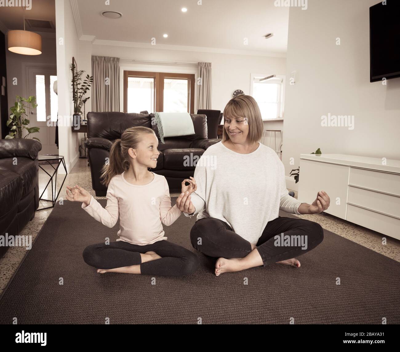 Arrêt COVID-19. La mère et la fille en quarantaine font du yoga à l'intérieur. Mère et fille faisant la méditation pendant le verrouillage. Santé, exercice séjour A Banque D'Images