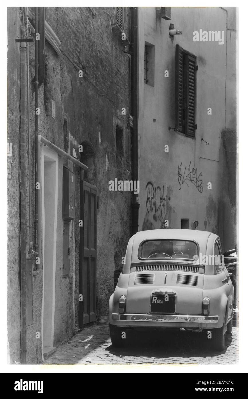 Photo de style ancien d'une Fiat Nuova 500 originale des années 1950 ou 1960 garée dans une ruelle à Trastevere, Rome, Lazio, Italie, Europe, noir et blanc Banque D'Images